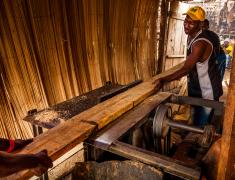 man works wood in the village in front of the capital Freetown, SIerra Leone